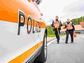 Die Polizistin und der Polizist vermessen eine Unfallstelle.