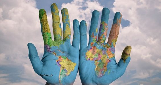 zwei Hände mit einer Weltkarte bemalt