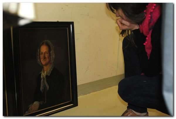 Frau betrachtet ein Gemälde einer älteren Dame