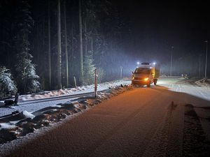 Lieferwagen steht am Rand der schneebedeckten Strasse. Kandelaber liegt vor dem Lfw auf dem Boden