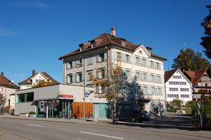 Das Obere Kaufhaus an der Hauptstrasse 24 in seinem Zustand 2013, vor dem aktuellen Umbau. Im Vordergrund der Anbau der Raiffeisenbank, im Hintergrund die historische Häuserzeile im Dorf. Foto: Denkmalpflege Appenzell Ausserrhoden